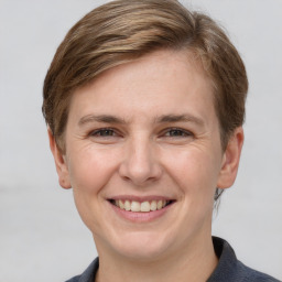 Joyful white young-adult female with short  brown hair and grey eyes