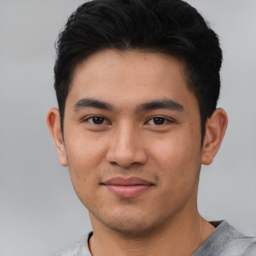 Joyful asian young-adult male with short  black hair and brown eyes