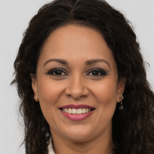 Joyful latino adult female with long  brown hair and brown eyes