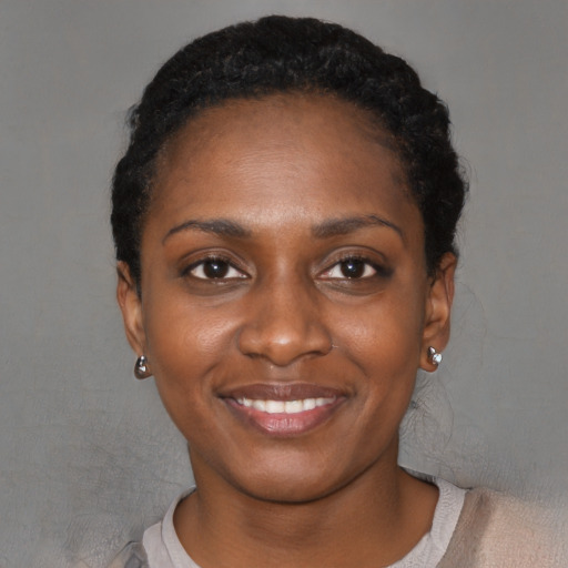 Joyful black young-adult female with short  black hair and brown eyes