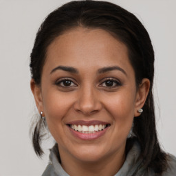 Joyful latino young-adult female with long  brown hair and brown eyes