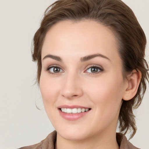 Joyful white young-adult female with medium  brown hair and grey eyes