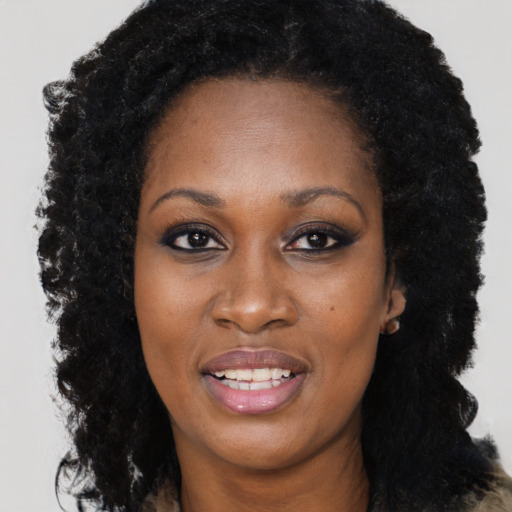 Joyful black young-adult female with long  black hair and brown eyes