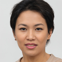 Joyful asian young-adult female with short  brown hair and brown eyes