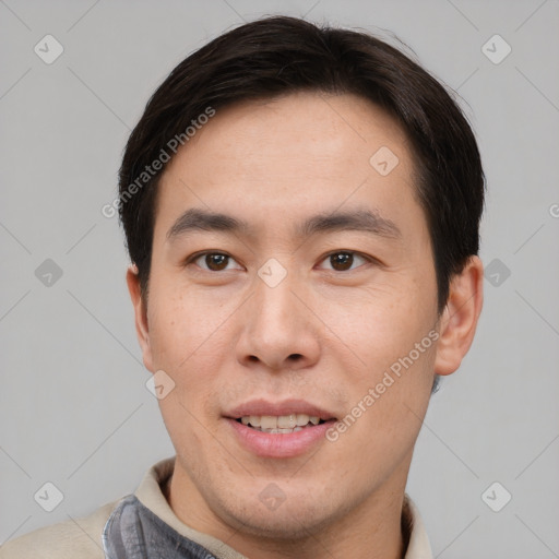 Joyful asian young-adult male with short  brown hair and brown eyes