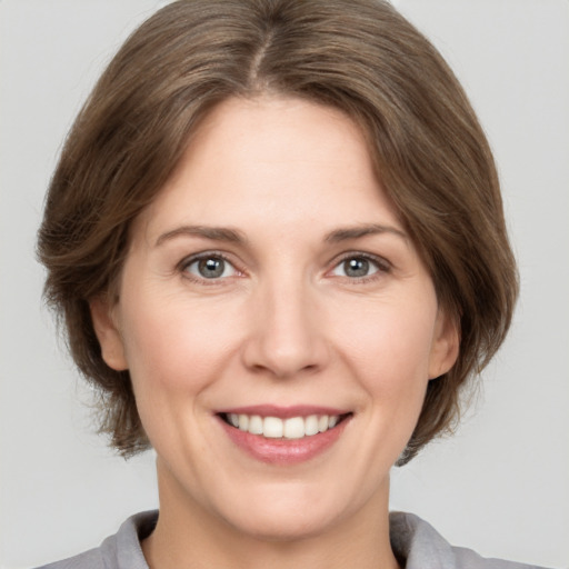 Joyful white young-adult female with medium  brown hair and grey eyes