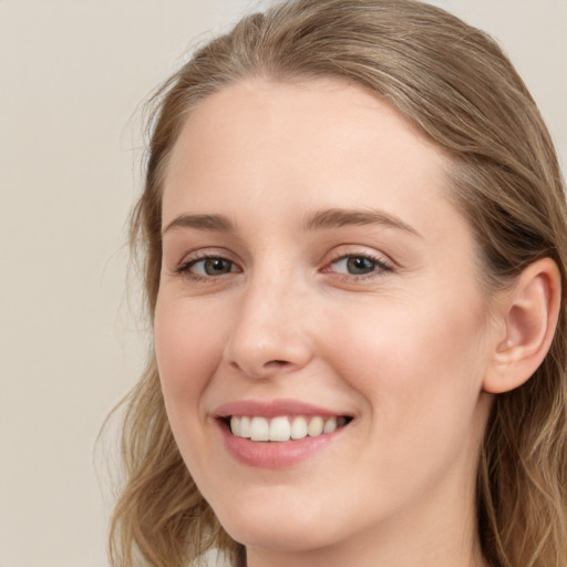 Joyful white young-adult female with long  brown hair and blue eyes