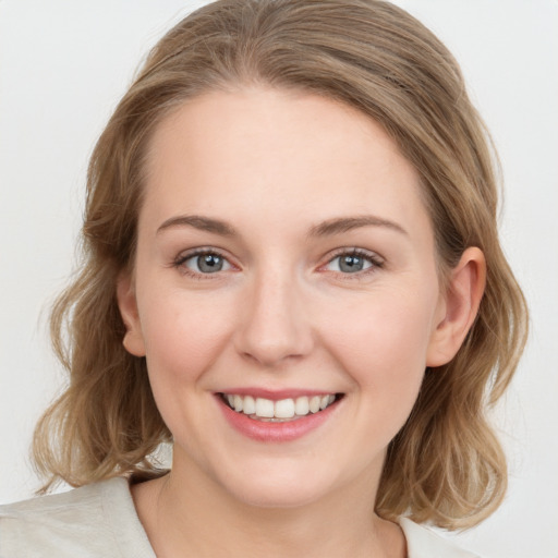 Joyful white young-adult female with medium  brown hair and blue eyes