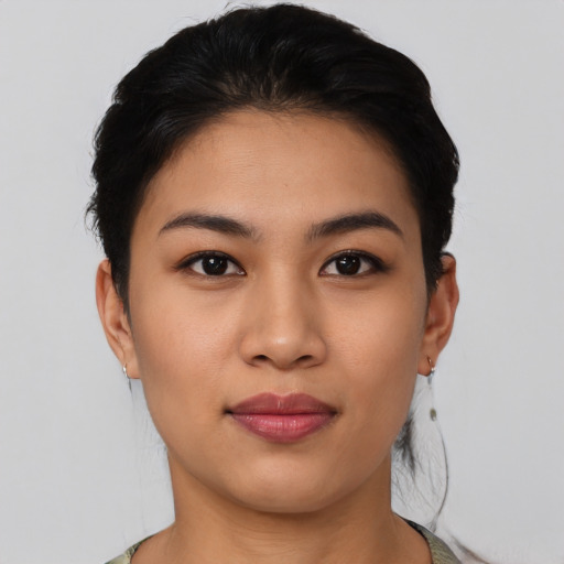 Joyful latino young-adult female with short  black hair and brown eyes