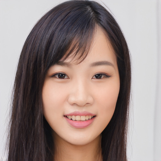 Joyful asian young-adult female with long  brown hair and brown eyes