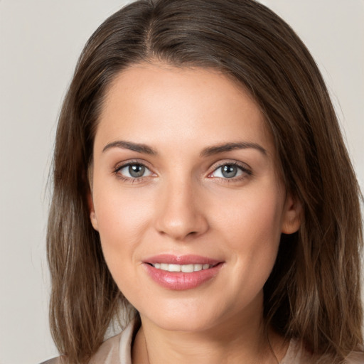 Joyful white young-adult female with medium  brown hair and green eyes