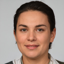 Joyful white young-adult female with medium  brown hair and grey eyes