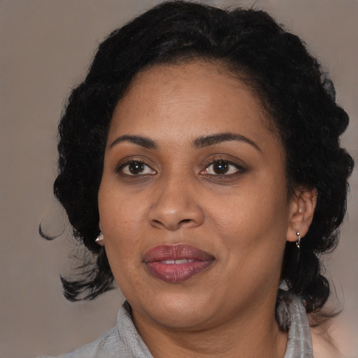 Joyful black adult female with medium  black hair and brown eyes