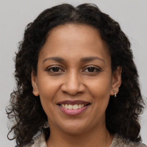 Joyful black adult female with medium  brown hair and brown eyes