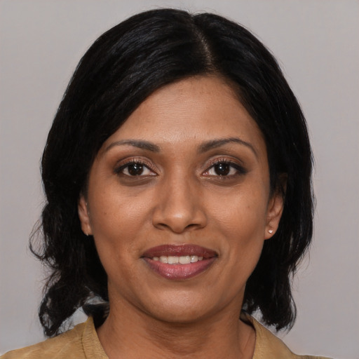 Joyful latino adult female with medium  black hair and brown eyes