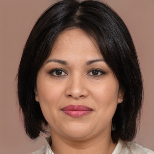 Joyful latino adult female with medium  brown hair and brown eyes
