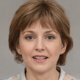 Joyful white adult female with medium  brown hair and grey eyes