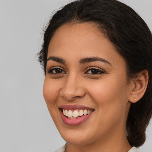 Joyful latino young-adult female with medium  brown hair and brown eyes