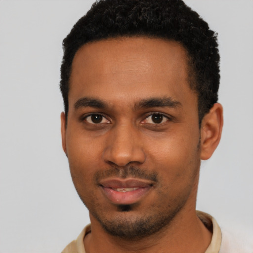 Joyful black young-adult male with short  black hair and brown eyes