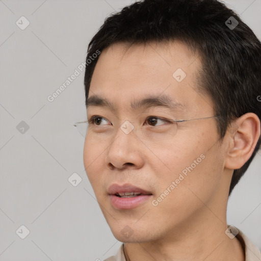 Joyful asian young-adult male with short  black hair and brown eyes