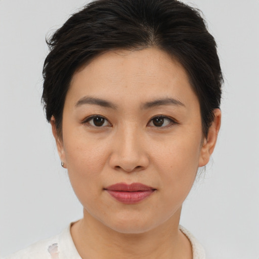 Joyful asian young-adult female with short  brown hair and brown eyes