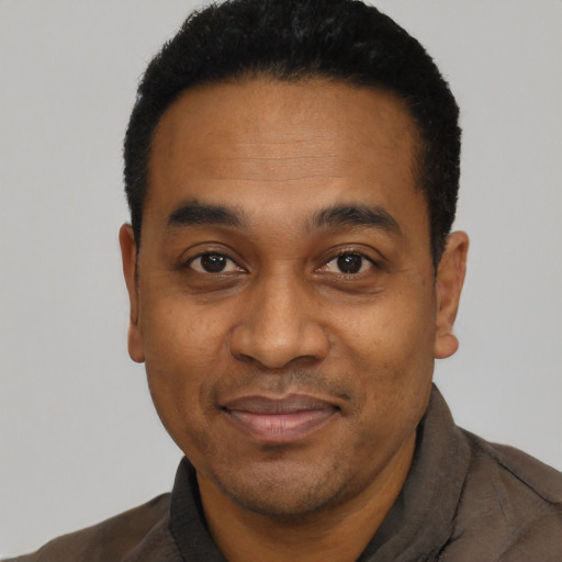 Joyful black young-adult male with short  black hair and brown eyes