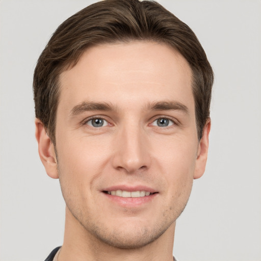 Joyful white young-adult male with short  brown hair and grey eyes