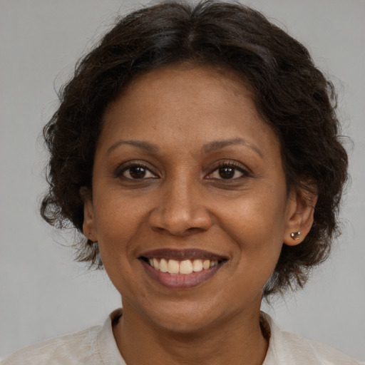 Joyful latino adult female with medium  brown hair and brown eyes