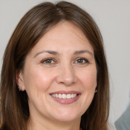 Joyful white adult female with long  brown hair and brown eyes