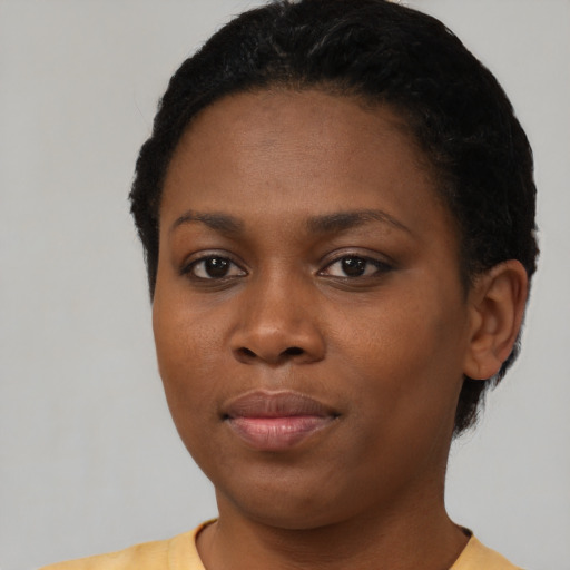Joyful black young-adult female with short  black hair and brown eyes