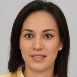 Joyful latino young-adult female with medium  brown hair and brown eyes