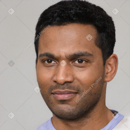 Joyful black young-adult male with short  black hair and brown eyes