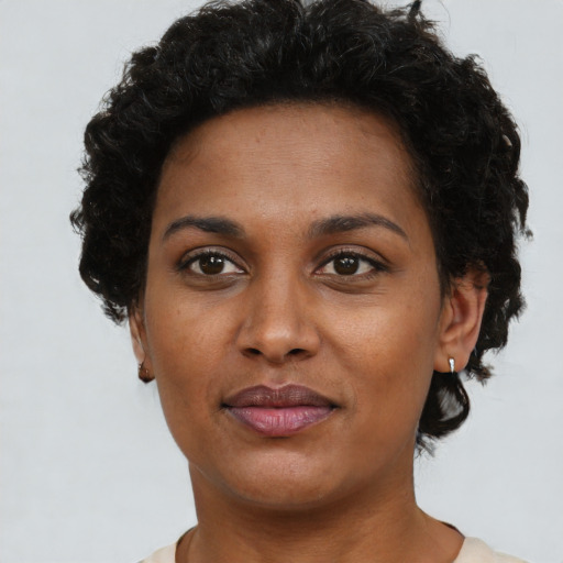 Joyful black young-adult female with short  brown hair and brown eyes