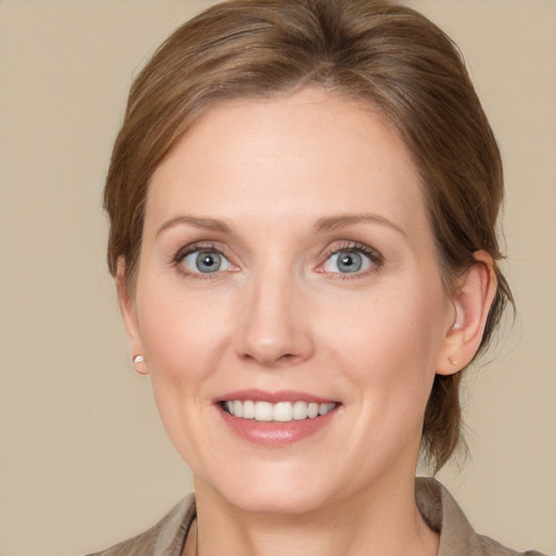 Joyful white adult female with medium  brown hair and blue eyes