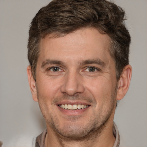 Joyful white adult male with short  brown hair and brown eyes