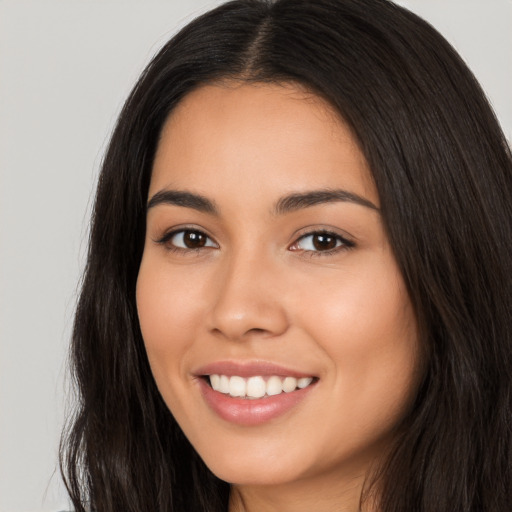 Joyful latino young-adult female with long  brown hair and brown eyes