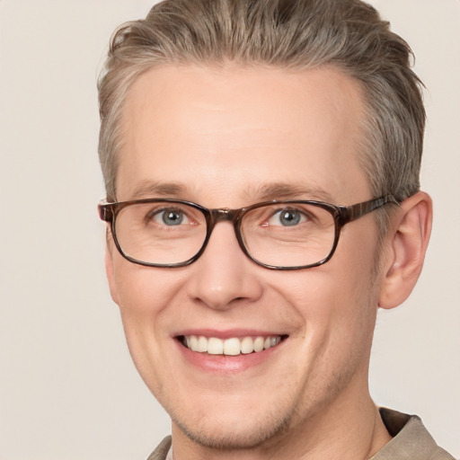 Joyful white adult male with short  brown hair and blue eyes