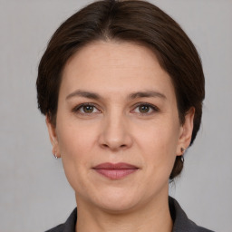 Joyful white adult female with medium  brown hair and grey eyes