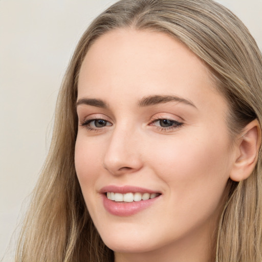 Joyful white young-adult female with long  brown hair and grey eyes