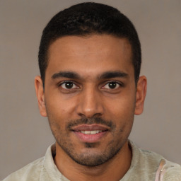 Joyful black young-adult male with short  brown hair and brown eyes