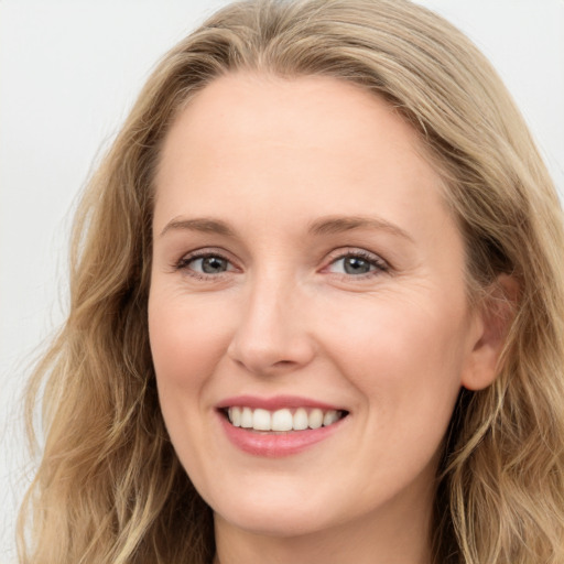 Joyful white young-adult female with long  brown hair and blue eyes