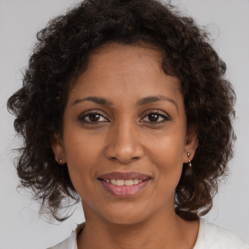 Joyful black young-adult female with medium  brown hair and brown eyes