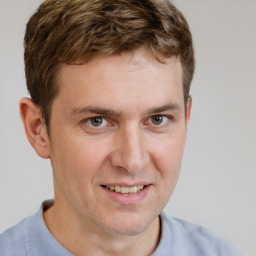 Joyful white young-adult male with short  brown hair and grey eyes