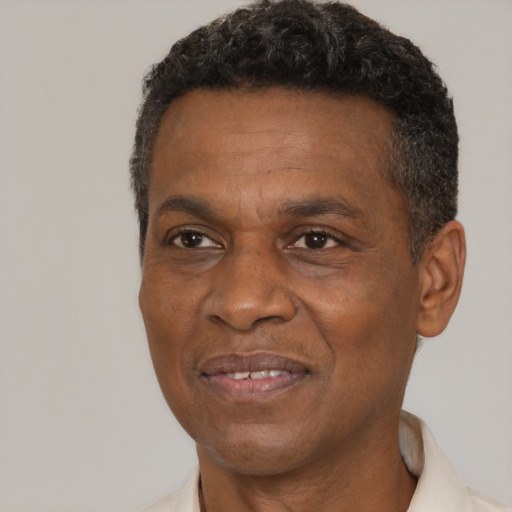 Joyful black adult male with short  black hair and brown eyes