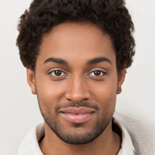 Joyful black young-adult male with short  brown hair and brown eyes