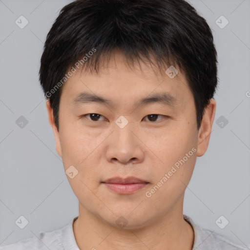 Joyful asian young-adult male with short  brown hair and brown eyes