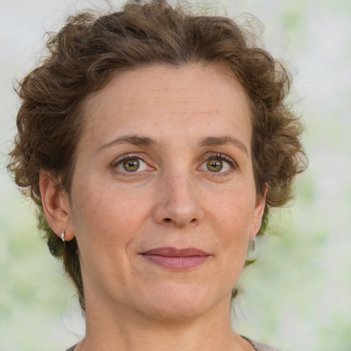 Joyful white adult female with medium  brown hair and green eyes