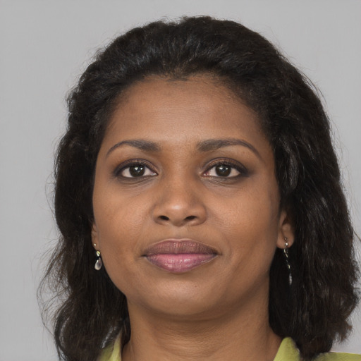 Joyful black adult female with long  brown hair and brown eyes