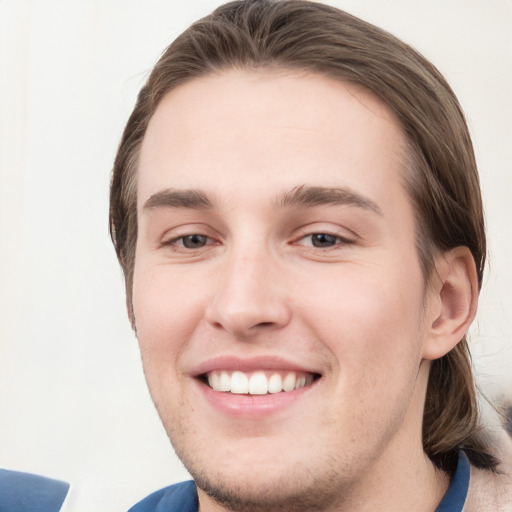 Joyful white young-adult male with medium  brown hair and grey eyes