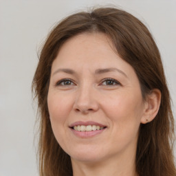 Joyful white adult female with long  brown hair and brown eyes